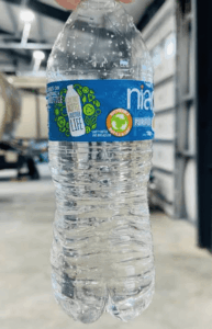 Clear plastic water bottle with blue label